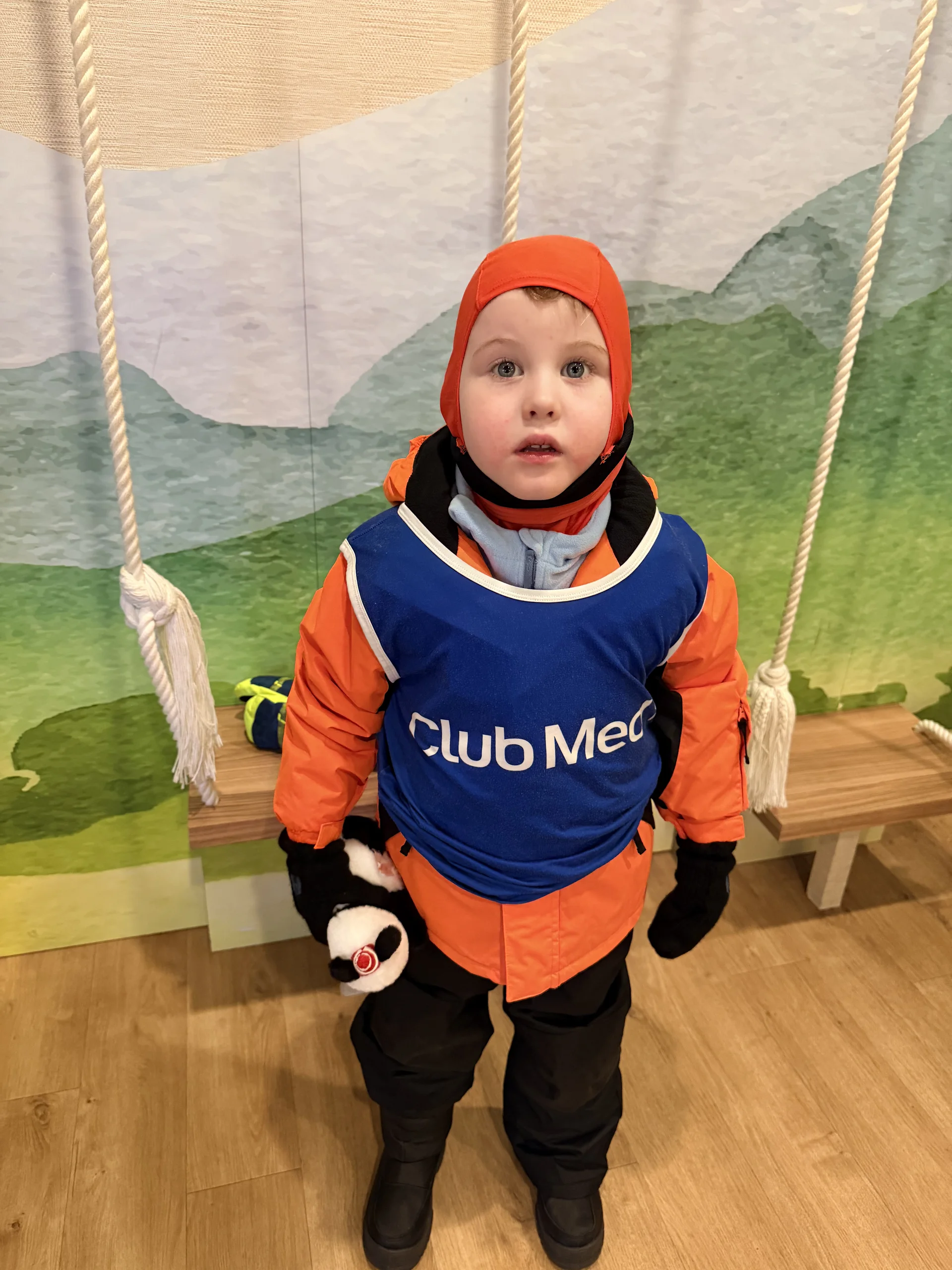 A child in a Club Med ski-school bib on a swing at the kids’ club at a Club Med resort in Hokkaido.