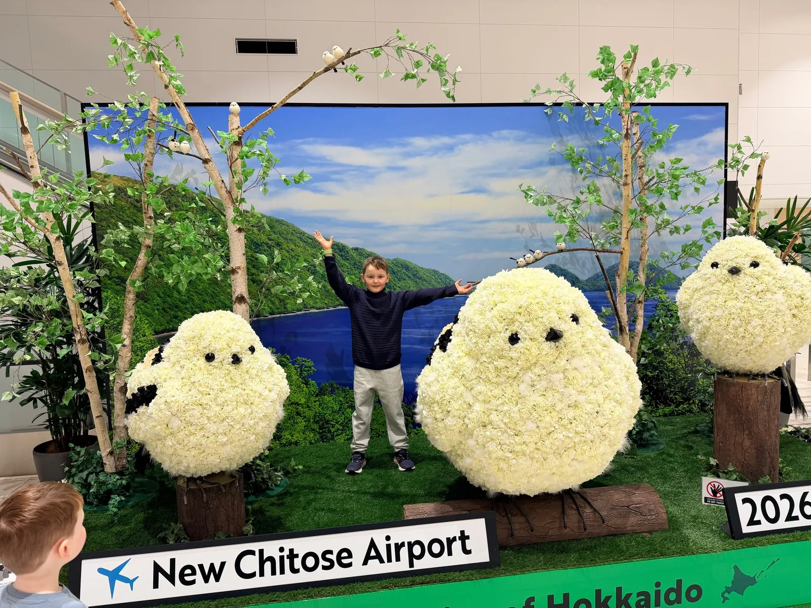 A child among giant fluffy shima-enaga bird sculptures at New Chitose Airport in Hokkaido.