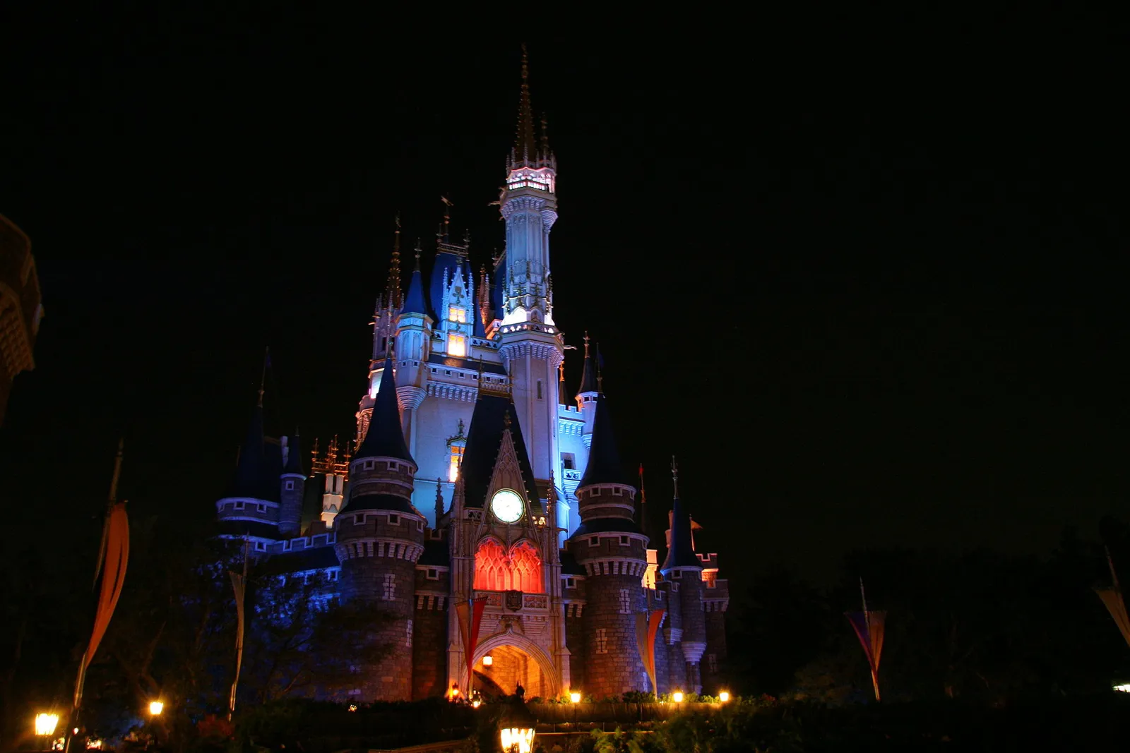 Cinderella Castle illuminated in blue at night at Tokyo Disneyland.